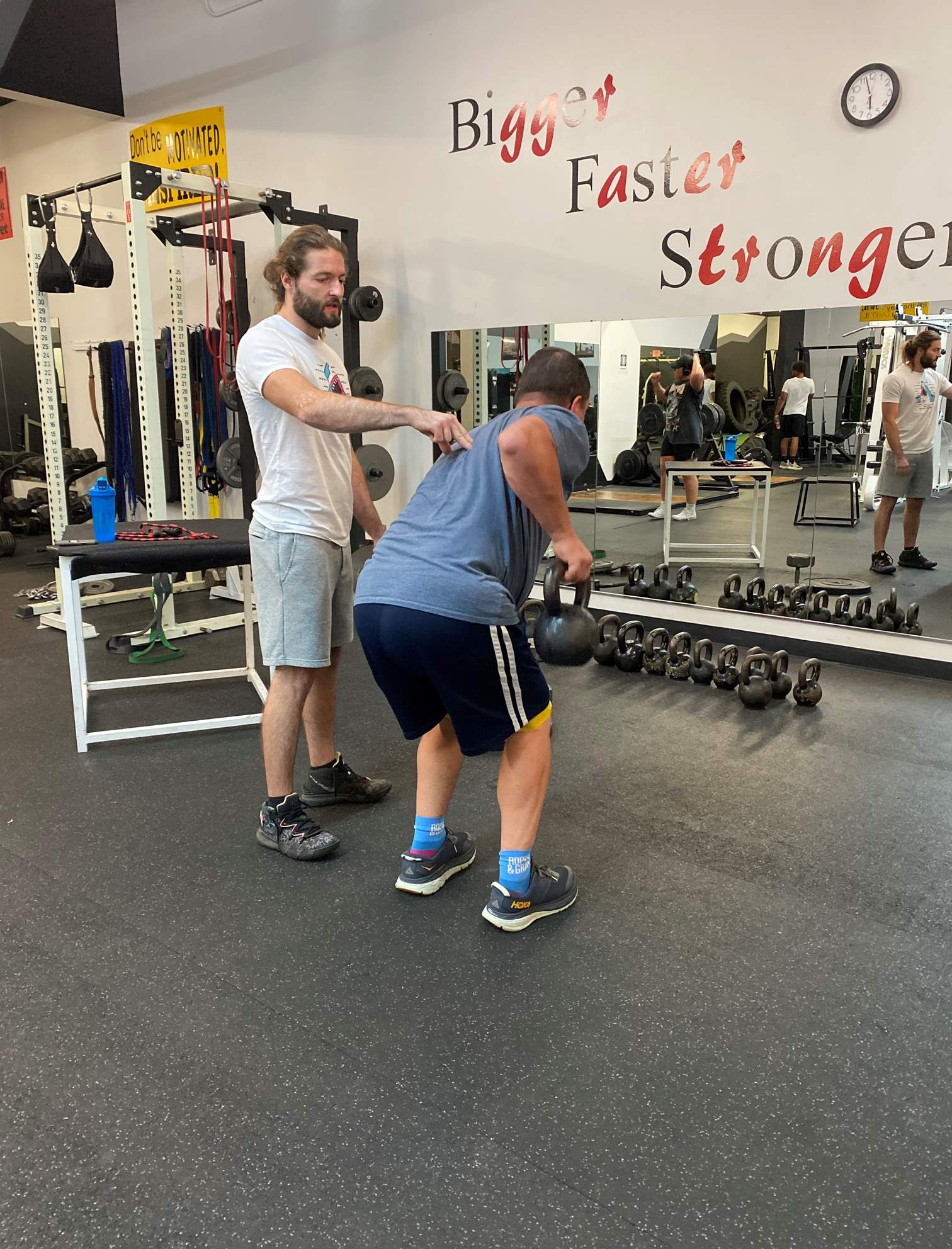 Adam coaching a client through a lift.